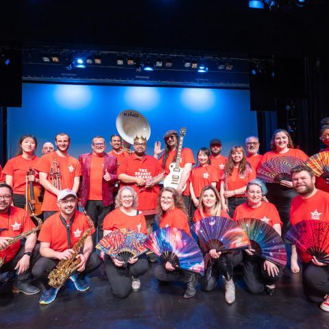 Staff performers pose on stage after their performance at BRASS Day