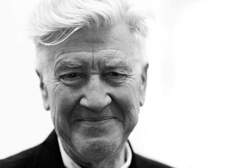 Close-up headshot of David Lynch against a blank background