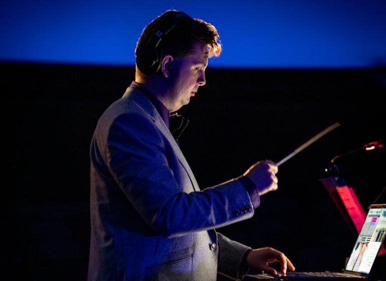 David Ibbett holding a conducting baton