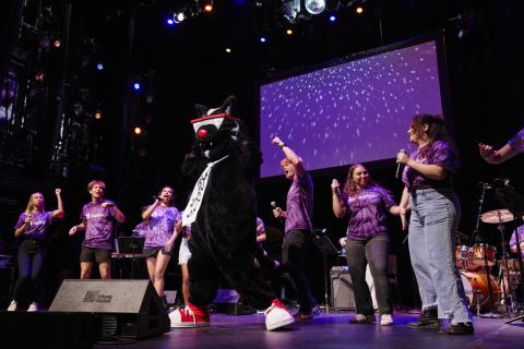Mingus dances on stage at orientation
