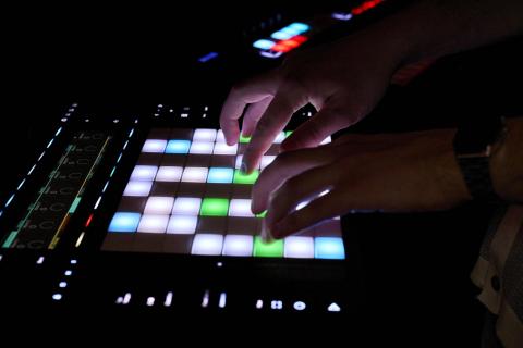 Close up of hands using a digital sampler in a studio environment