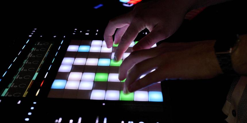 Close up of hands using a digital sampler in a studio environment