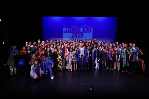 group photo of students faculty and staff on the stage