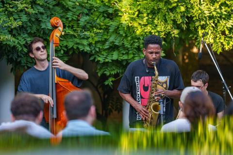 Bass and Sax player side by side playing music in a park