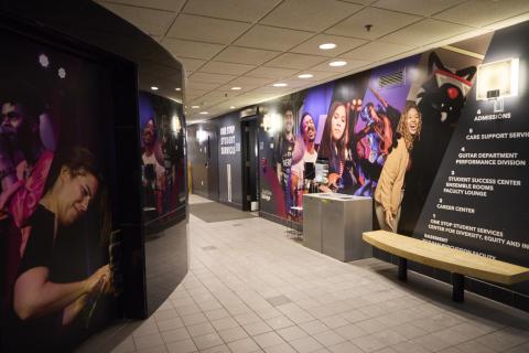 Hallway at 921 Boylston featuring the One Stop sign and environmental graphics with large photos of students
