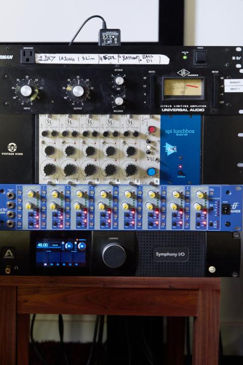 a series of rack-mount effects stacked on a table in a studio