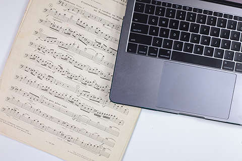 Sheet music next to a computer