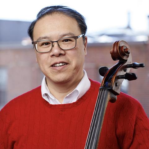Cellist Andew Mark poses with his instrument 