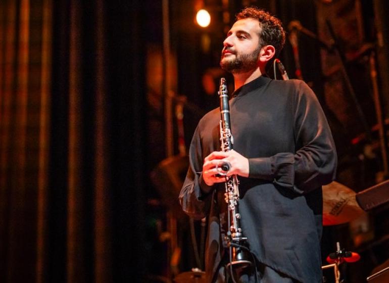 Mehrpouya Daneshvar holding a clarinet on stage