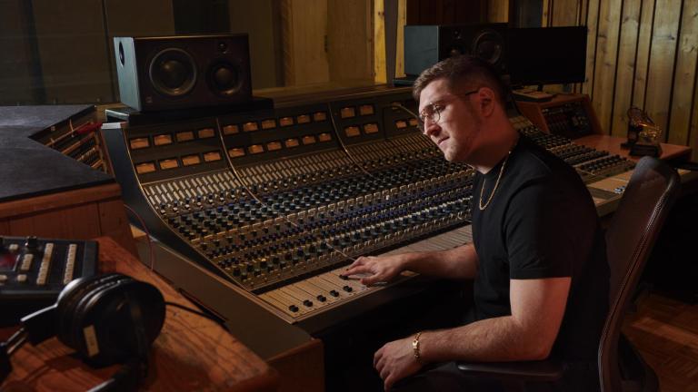 Charlie Rosen '12 behind a mixing board in a studio