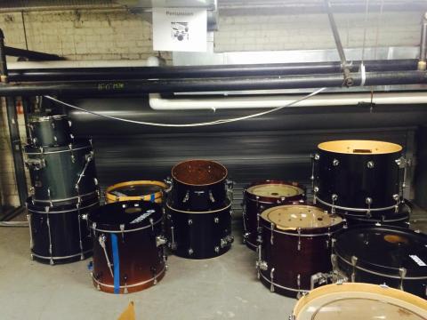 A pile of used drumset pieces in a storage room