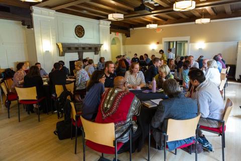Staff and faculty have discussions at tables in the Loft
