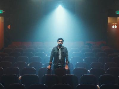 Man standing in seating area under a spotlight