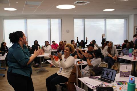 A music therapist clapping and singing to a classroom of teens