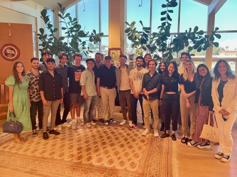 A group of Berklee interns in a Los Angeles conference room standing with FINNEAS