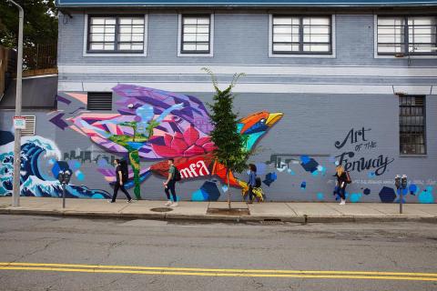 Side of building in the Fenway with a bird mural and students walking