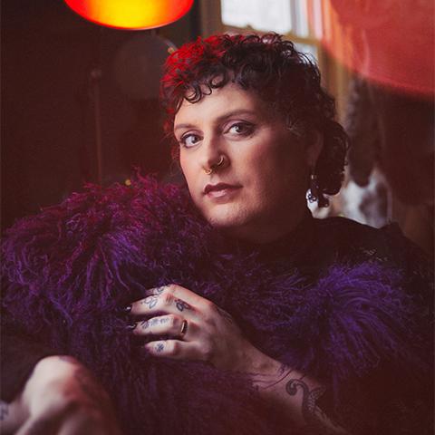 Jessye poses for the camera in front of orange lights 