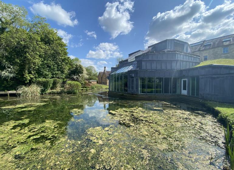 Real World Studios seen from the outside on a sunny day with a verdant pond in the foreground
