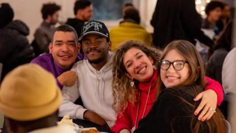 A group of students hug each other and smile at the camera 