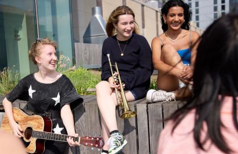 Summer Programs Aspire students sit outside with their instruments