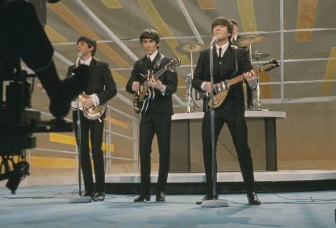 The Beatles performing on the stage of the 'Ed Sullivan Show' in 1964