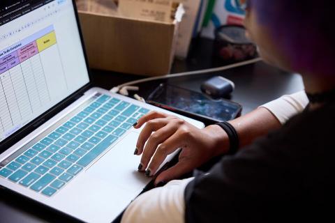 Stock photo of a closeup of someone's hands as they use a laptop.