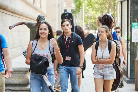 students walking with instruments on their backs