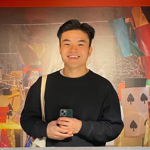 William Tiong taking a selfie in front of a piece of contemporary art 