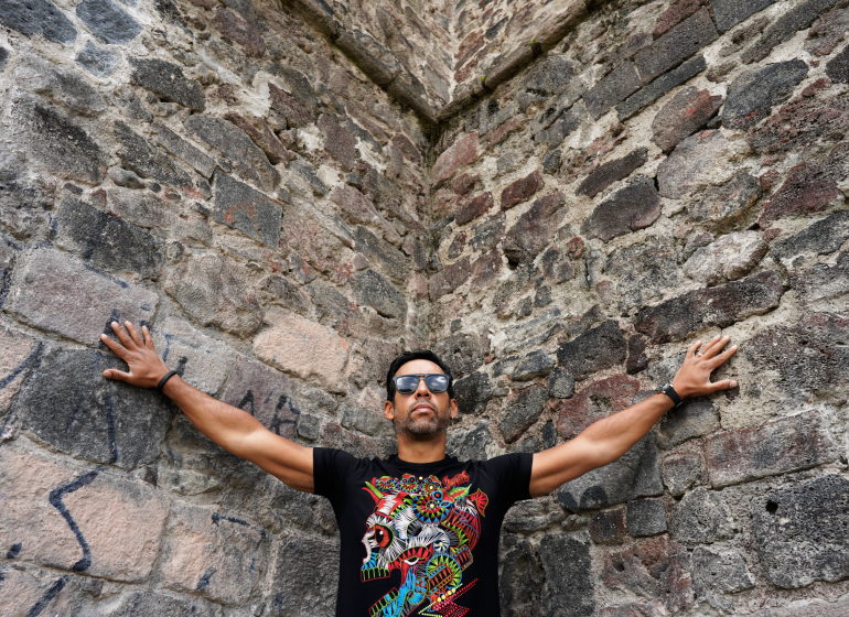 Antonio Sánchez in the corner of a cobblestone wall